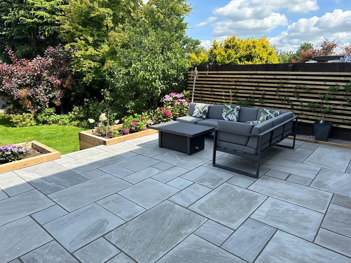 Wide patio view with grey porcelain slabs and corner lounge seating, Birstall