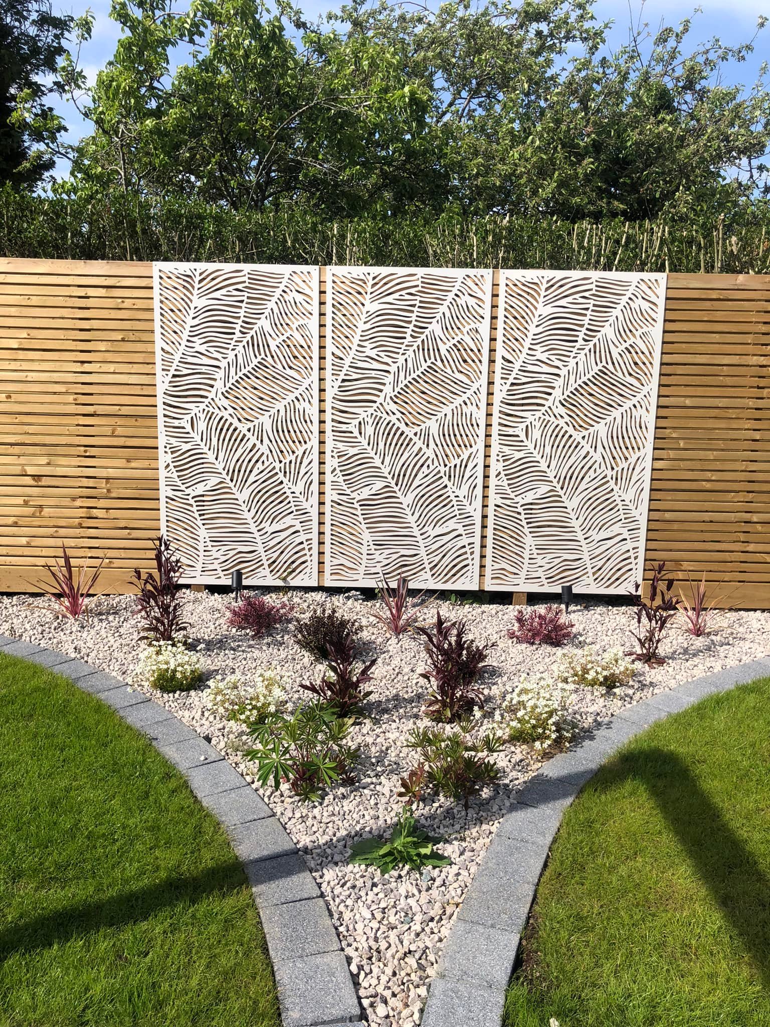 Ornamental laser-cut screen panels with planting and gravel border, Evington