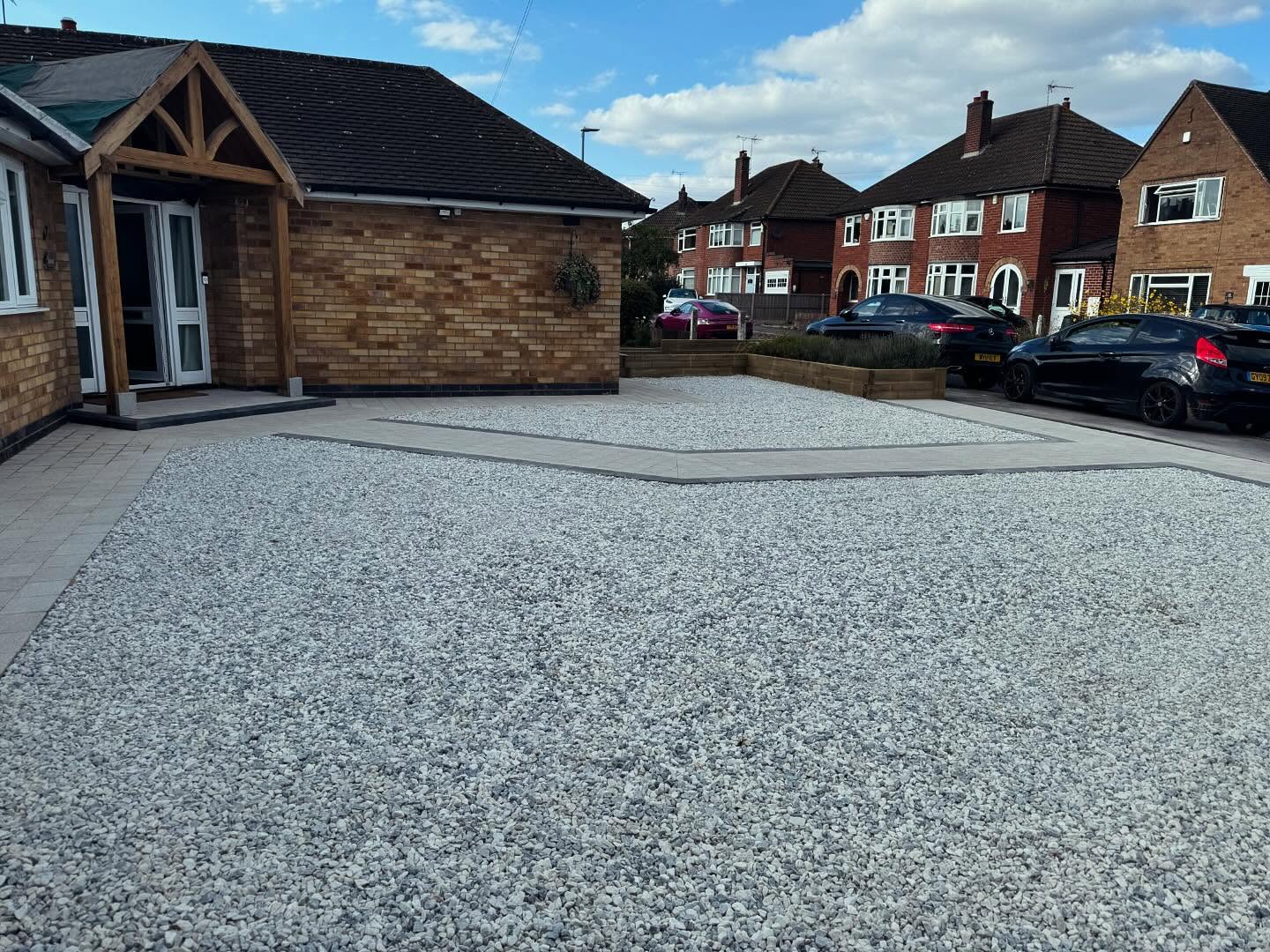 Wide overview of gravel driveway from street level with timber planter — Kirby Muxloe