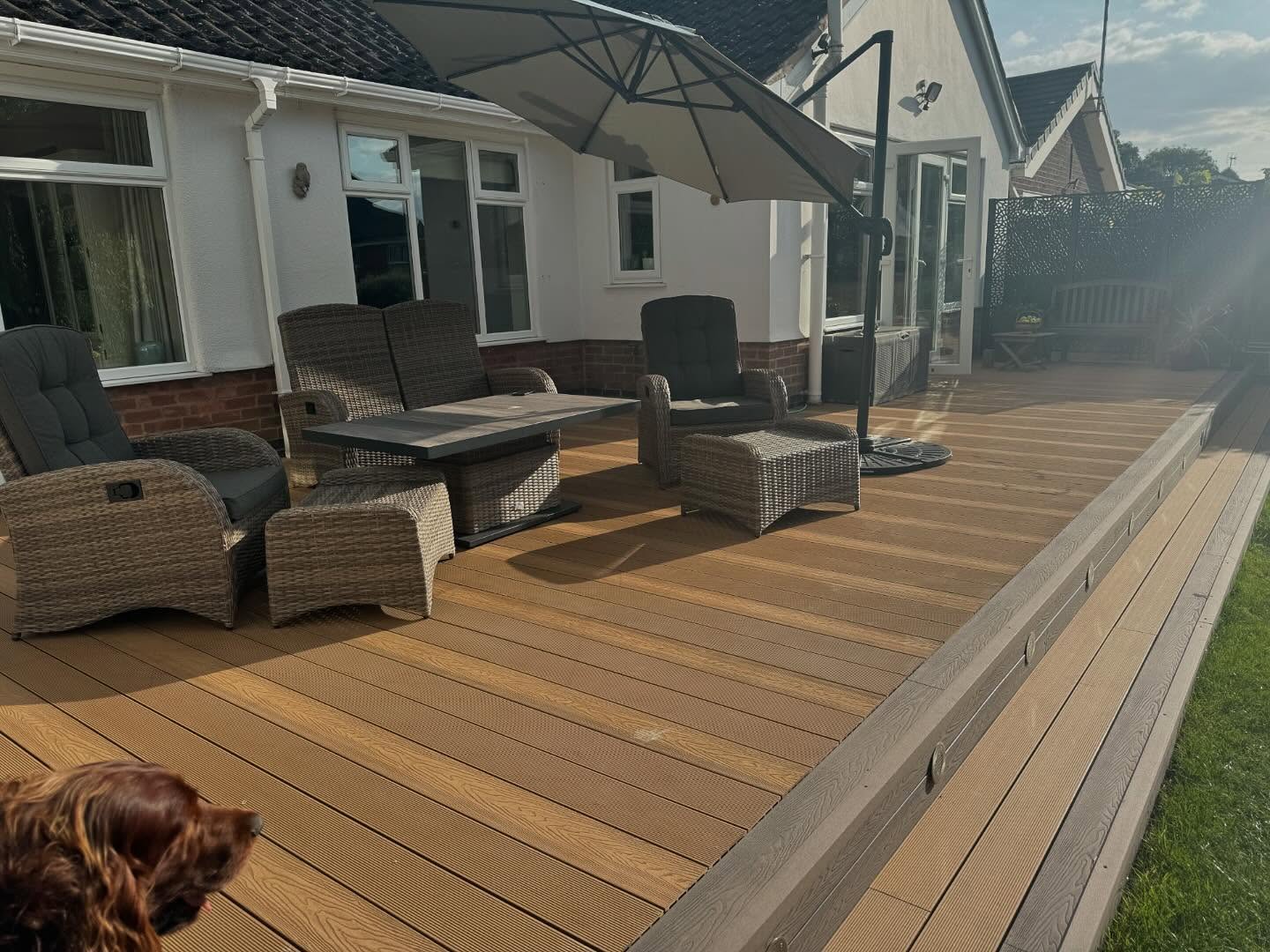 Composite decking Kirby Muxloe — teak-tone boards with dark fascia and laser-cut screens