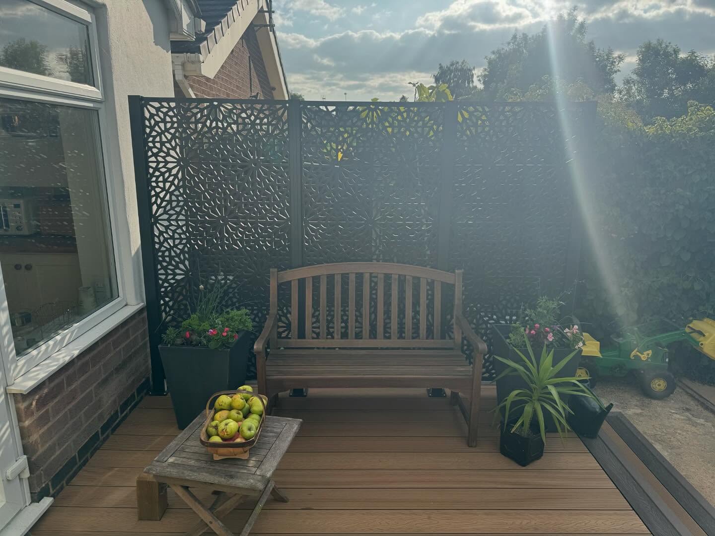 Side seating zone with laser-cut metal privacy screens and timber bench — Kirby Muxloe