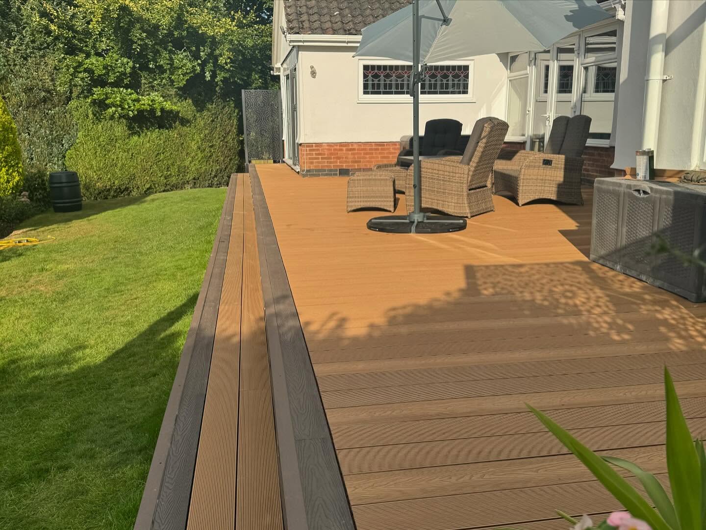 Side elevation view of composite deck at sunset with lawn — Kirby Muxloe