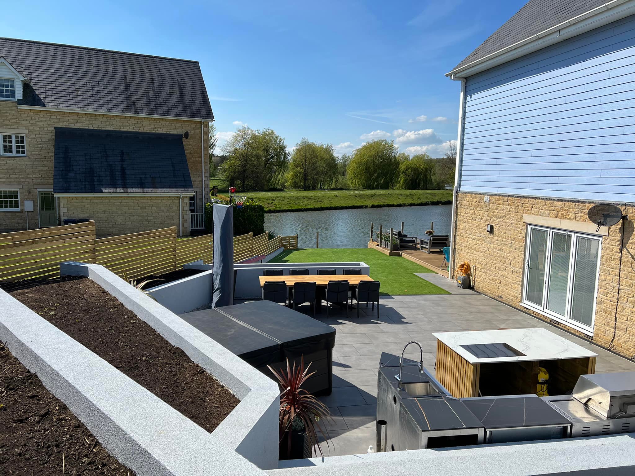 Tiered garden makeover Peterborough — bird's eye view with outdoor kitchen and lake
