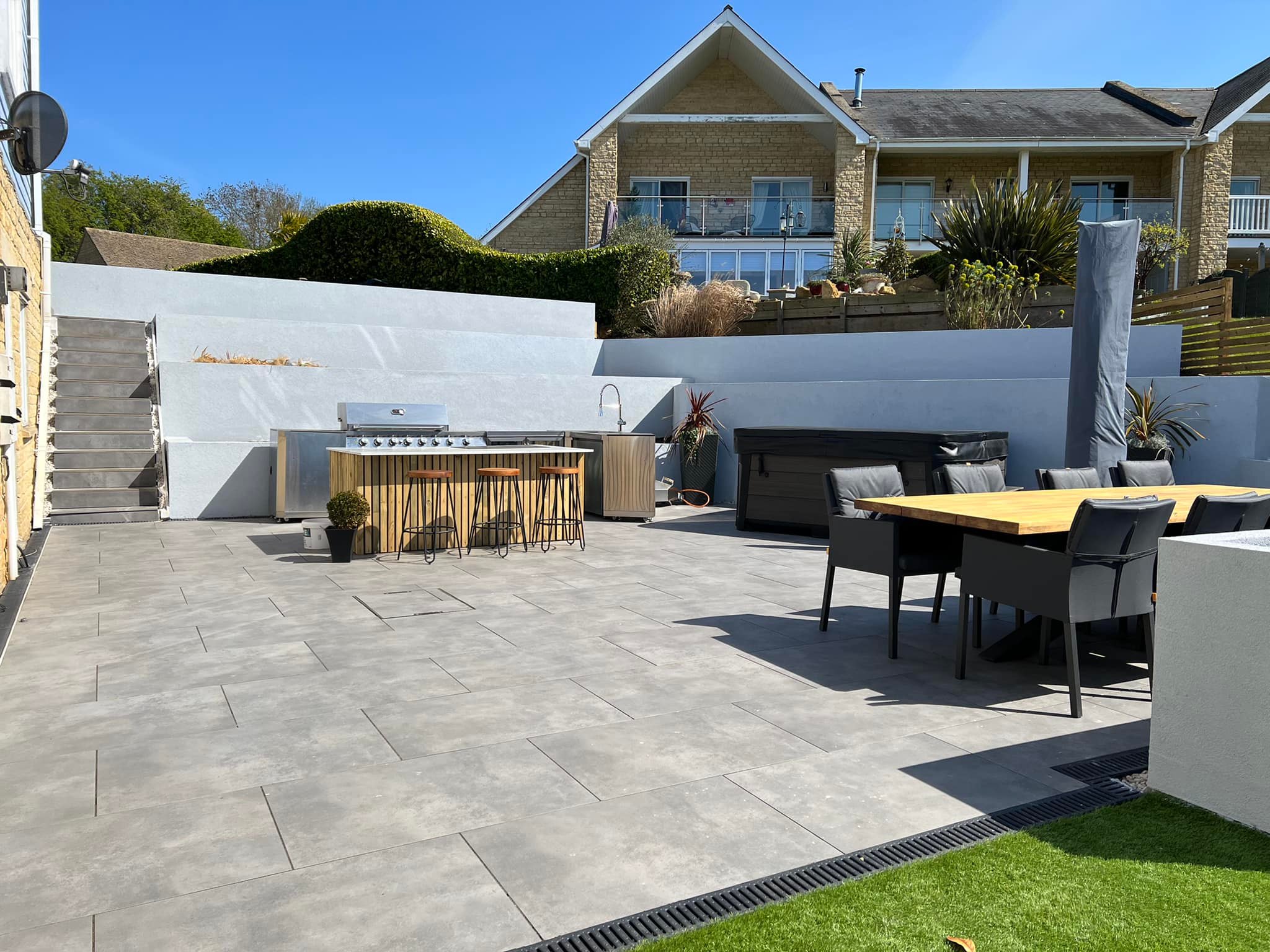 Completed porcelain patio with outdoor dining set and kitchen — finished garden, Peterborough