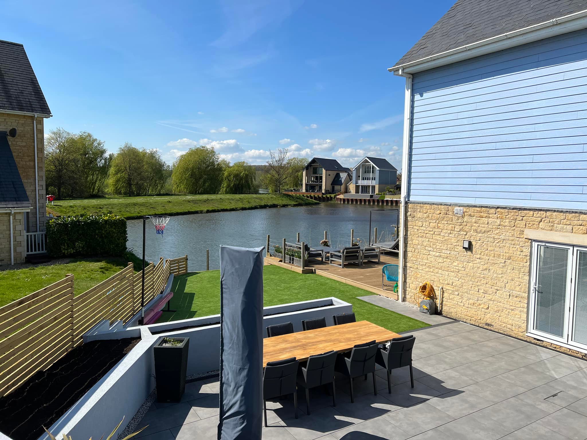 View from upper level overlooking lake — garden dining area and waterfront decking, Peterborough