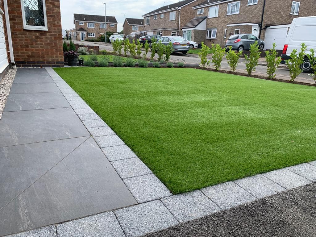 Porcelain path edge detail with artificial grass and granite sett edging, Wigston